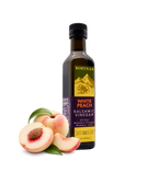 Kofinas White Peach balsamic vinegar in a bottle with a fresh white peach and slices