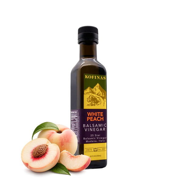 Kofinas White Peach balsamic vinegar in a bottle with a fresh white peach and slices
