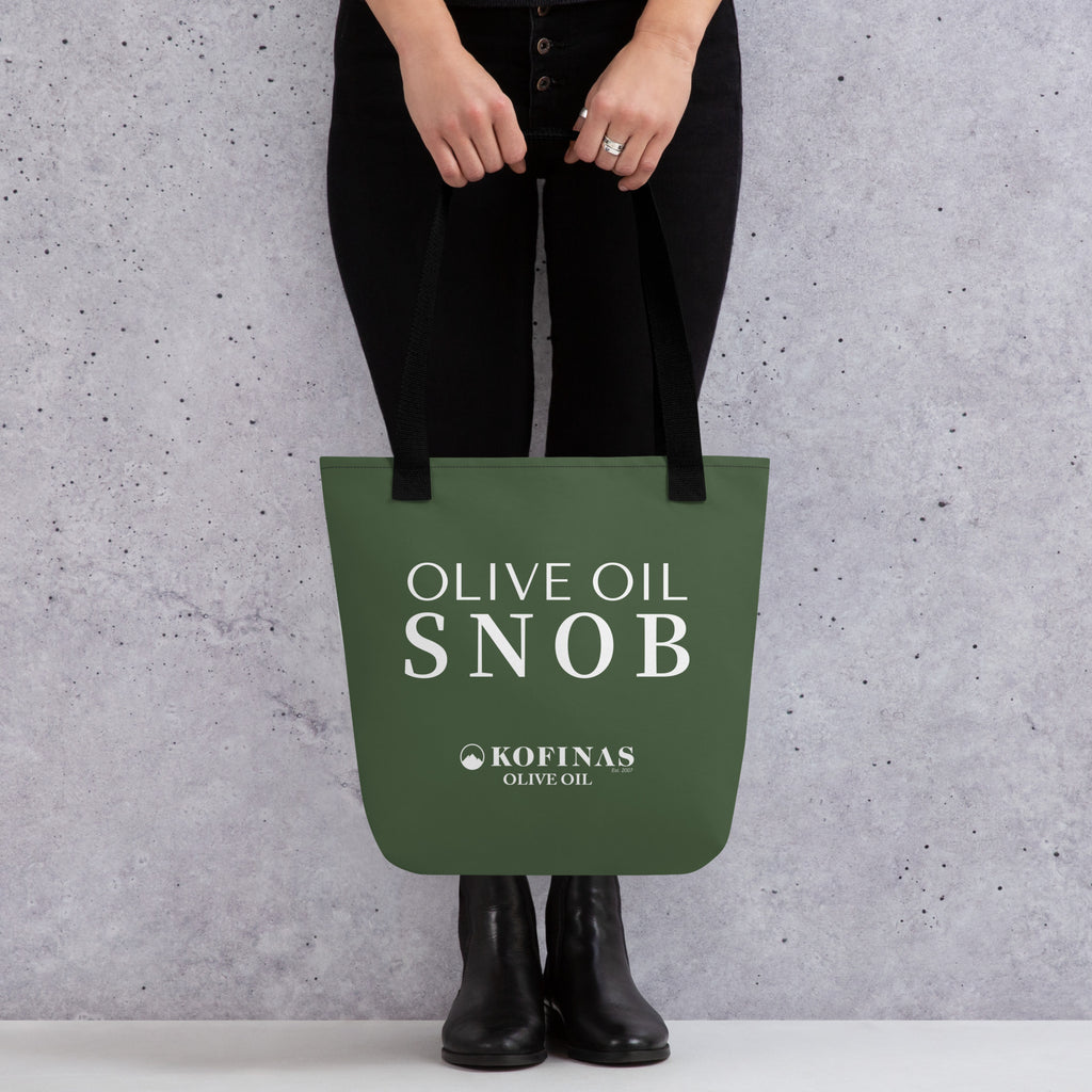 Person holding the olive-green Olive Oil Snob tote bag by its handles