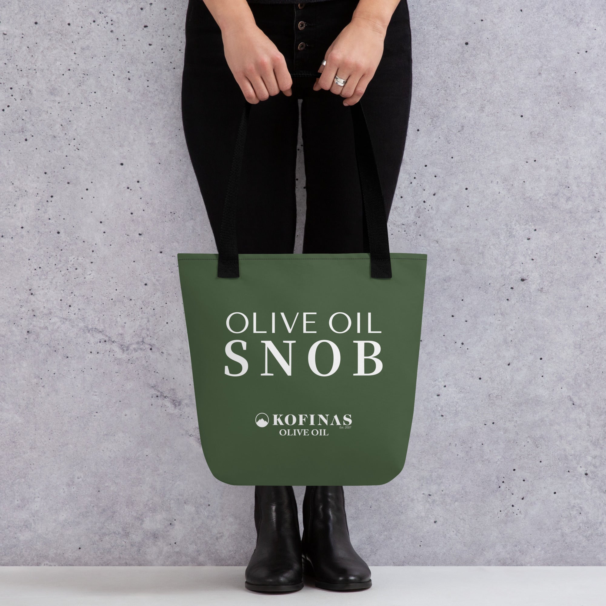 Person holding the olive-green Olive Oil Snob tote bag by its handles