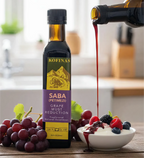 Kofinas Saba grape must reduction poured over a bowl of yogurt and fresh berries